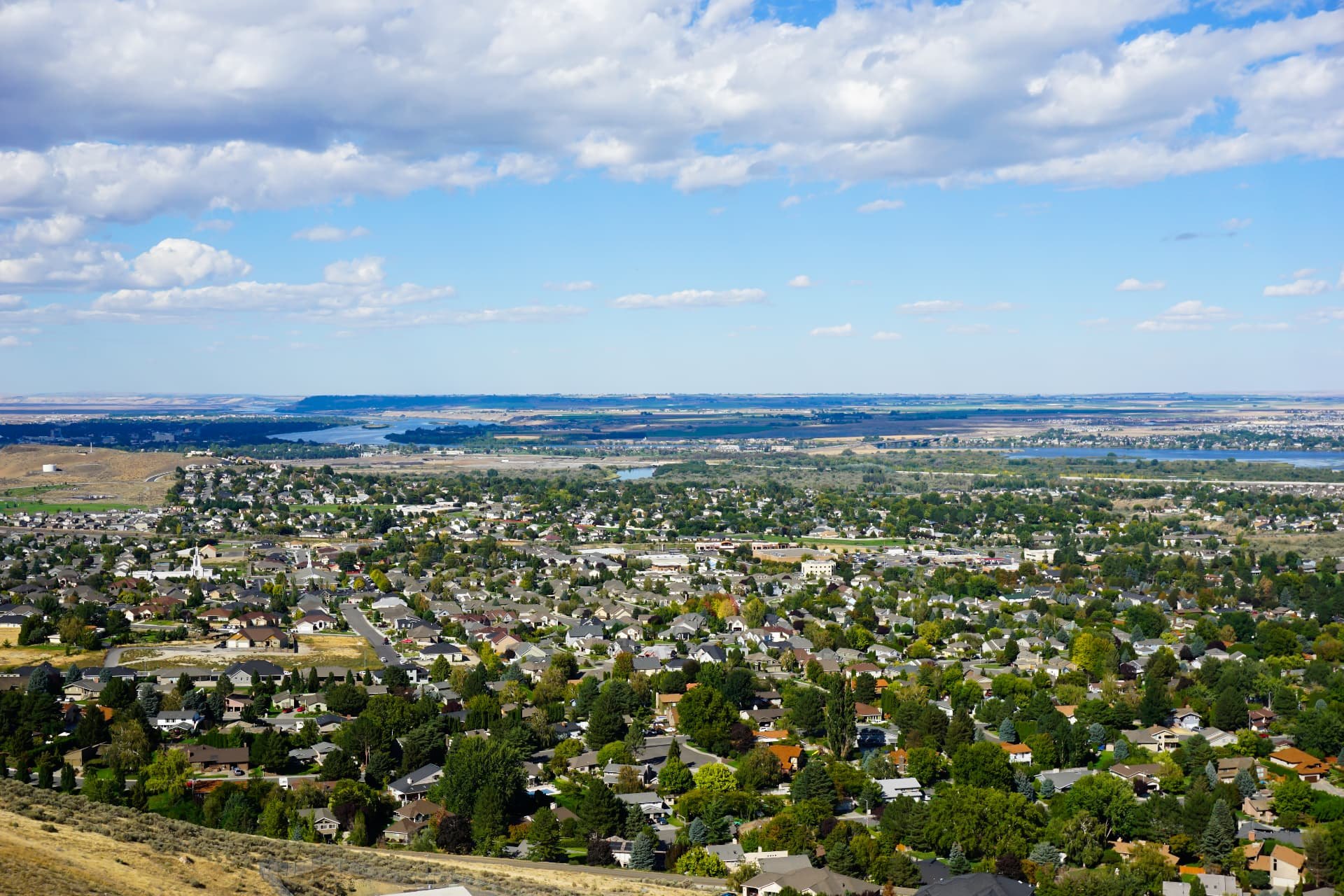 Overlook of Richland, Washington neighborhoods and tree-lined streets with the Columbia River in the distance